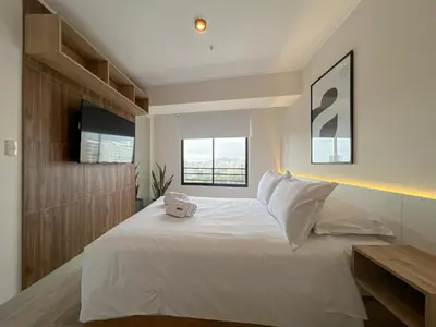 a bedroom with a large white bed with a window at Studio 4 by Geko in Lima