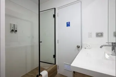 a bathroom with a glass shower and a sink at Soho by Geko in Lima
