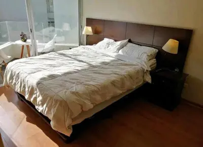 a large bed in a bedroom with a window at Departamento amoblado vacacional in Lima
