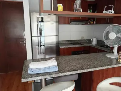 a kitchen with a refrigerator and a counter with a fan at Departamento amoblado vacacional in Lima