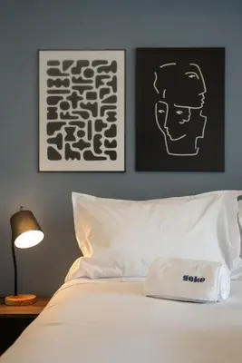 a bed with a white pillow and a picture of a man at Sahara Sunset 2BR by Geko in Lima