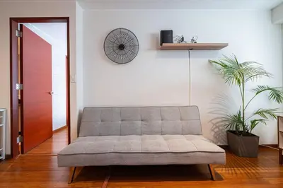 a couch in a living room with a clock on the wall at Taurus 2BR by Geko in Lima