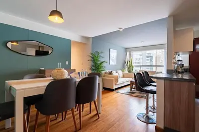 a kitchen and living room with a table and chairs at Taurus 2BR by Geko in Lima
