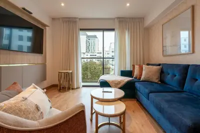 a living room with a blue couch and a table at Premium 2BR Apartment Steps from Kennedy Park in Lima