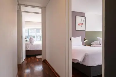 a room with two beds and a hallway with a mirror at The Kennedy 3BR by Geko in Lima