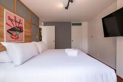 a bedroom with a white bed and a flat screen tv at The Kennedy 3BR by Geko in Lima