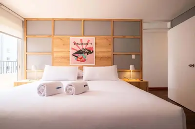a bedroom with a large white bed with two pillows at The Kennedy 3BR by Geko in Lima