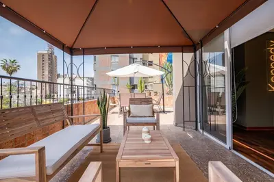 a patio with benches and tables on a balcony at The Kennedy 3BR by Geko in Lima
