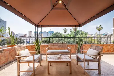 a patio with two chairs and a table on a roof at The Kennedy 3BR by Geko in Lima