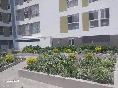 an apartment building with a garden in front of it at Moderno departamento con vista panorámica cerca a los centros comerciales in Lima