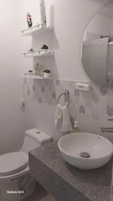 a bathroom with a sink and a toilet and a mirror at Moderno departamento con vista panorámica cerca a los centros comerciales in Lima