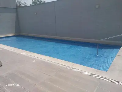 a swimming pool with blue water in a building at Moderno departamento con vista panorámica cerca a los centros comerciales in Lima