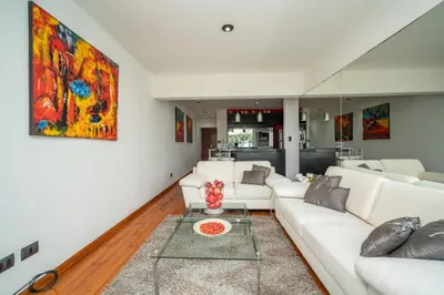 a living room with white furniture and a painting on the wall at Manuel Tovar Apartment in Miraflores 1 BDR in Lima