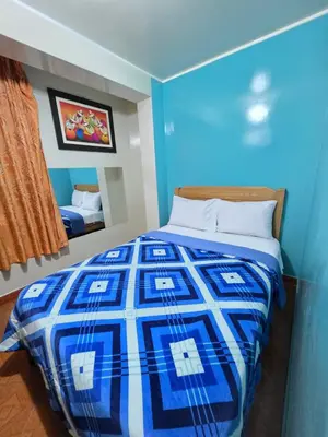 a bedroom with a blue and white bed with a mirror at Hospedaje Leo in Lima