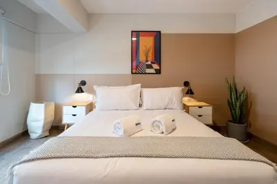 a bedroom with a large white bed with towels on it at Wonderland 2BR by Geko in Lima