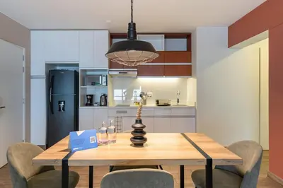 a kitchen and dining room with a wooden table and chairs at Wonderland 2BR by Geko in Lima