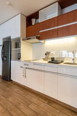 a kitchen with white cabinets and a refrigerator at Wonderland 2BR by Geko in Lima