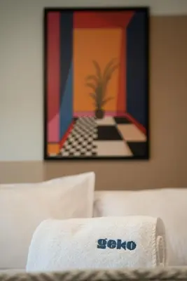 a towel sitting on top of a bed with a painting at Wonderland 2BR by Geko in Lima