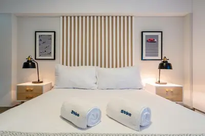 a bedroom with a large white bed with two lamps at Wonderland 2BR by Geko in Lima