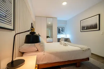 a bedroom with a bed with a lamp and a desk at Wonderland 2BR by Geko in Lima