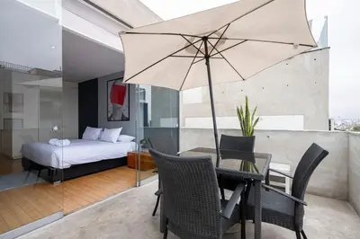 a bedroom with a bed and a table with an umbrella at Dopamine Duplex by Geko in Lima
