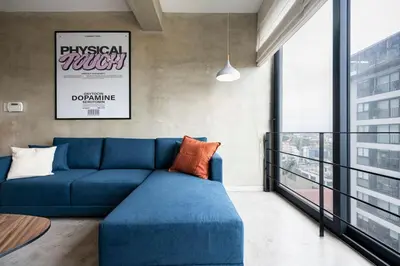 a living room with a blue couch and a large window at Dopamine Duplex by Geko in Lima