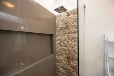 a bathroom with a walk in shower and a sink at Dopamine Duplex by Geko in Lima