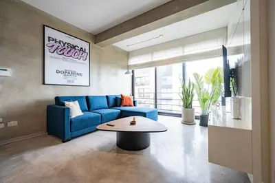 a living room with a blue couch and a table at Dopamine Duplex by Geko in Lima
