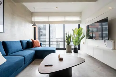 a living room with a blue couch and a table at Dopamine Duplex by Geko in Lima