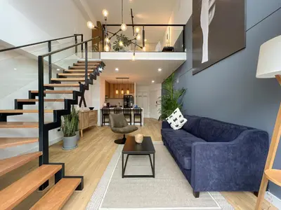 a living room with a blue couch and stairs at Francia by Geko in Lima