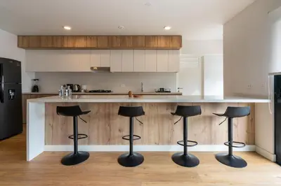 a kitchen with a counter with black stools at Francia by Geko in Lima