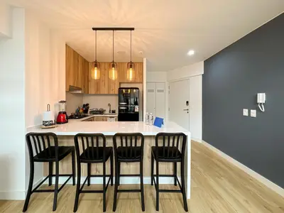 a kitchen with a island with four chairs around it at Francia by Geko in Lima