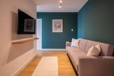 a living room with a couch and a blue wall at Francia by Geko in Lima