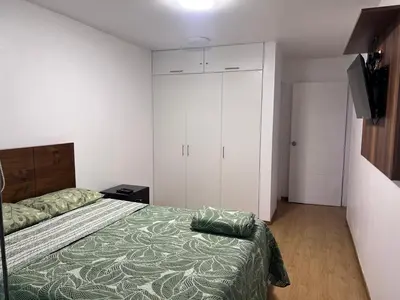 a bedroom with a bed and a television in it at Alquilo Departamento en Playa Pulpos in Lurín