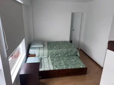 a small room with two beds and a door at Alquilo Departamento en Playa Pulpos in Lurín