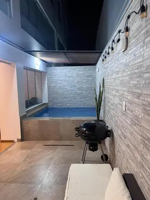 a room with a black chair in front of a brick wall at Alquilo Departamento en Playa Pulpos in Lurín