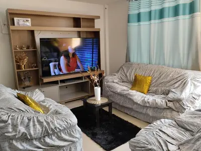 a living room with a couch and a flat screen tv at Acogedora casa en ICA - PERU in Ica