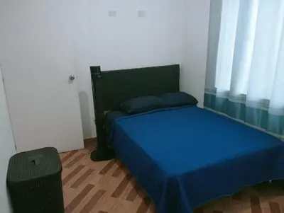 a bedroom with a bed with blue sheets and a window at Acogedora casa en ICA - PERU in Ica
