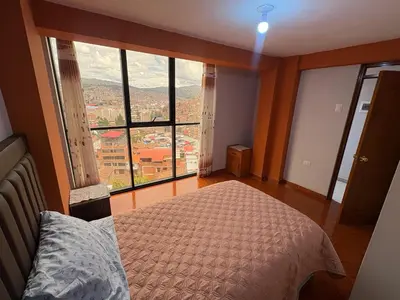 a bedroom with a bed and a large window at Nido Cusqueño in Cusco
