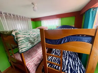 two bunk beds in a room with green walls at Nido Cusqueño in Cusco