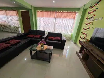 a living room with black couches and a table at Nido Cusqueño in Cusco