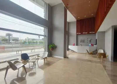 a lobby with chairs and tables and a large window at Loft Ale Piso 22 in Lima