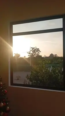 a window with a view of a beach and the sunset at Casa Sunampe Chincha - 2do Piso in Sunampe
