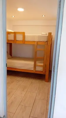 two bunk beds in a room with a wooden floor at Casa Sunampe Chincha - 2do Piso in Sunampe
