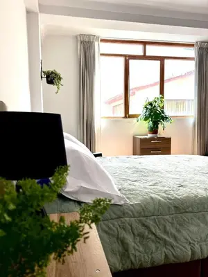 a bedroom with a bed and a window at Casa Raíz Cusco in Cusco