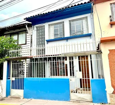 a white and blue house with a blue gate at Casa Raíz Cusco in Cusco
