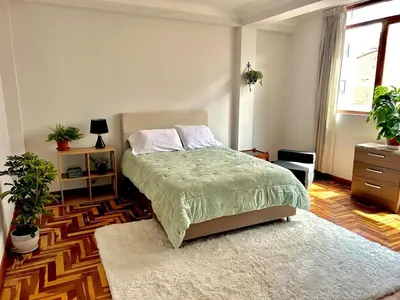 a bedroom with a bed and a rug at Casa Raíz Cusco in Cusco
