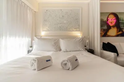 a bedroom with a white bed with two towels on it at Barranco Modern Apartments with Rooftop Pool by Geko in Lima