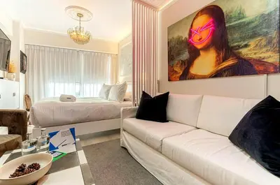 a living room with a white couch and a painting at Barranco Modern Apartments with Rooftop Pool by Geko in Lima