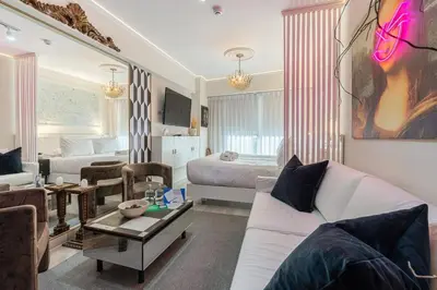 a living room with a white couch and a bedroom at Barranco Modern Apartments with Rooftop Pool by Geko in Lima